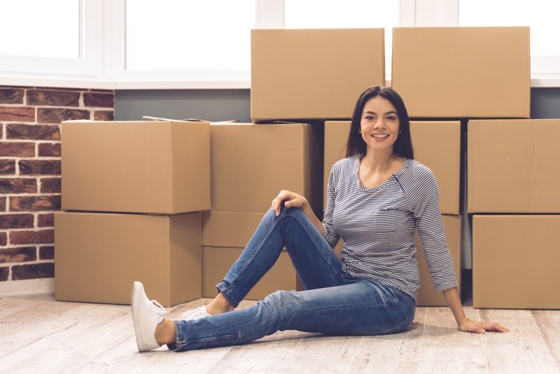 Woman sits in front of moving boxes