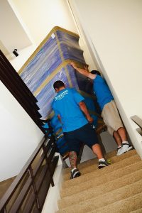 two dallas movers lift furniture down stairwell