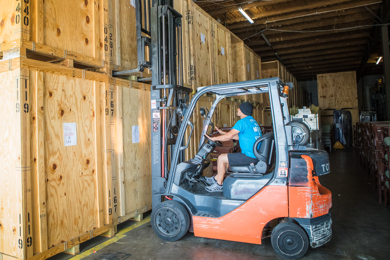 element moving employee carefully packing warehouse containers